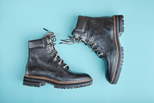 istock Pair of black genuine leather boots. Blue background 1208462554