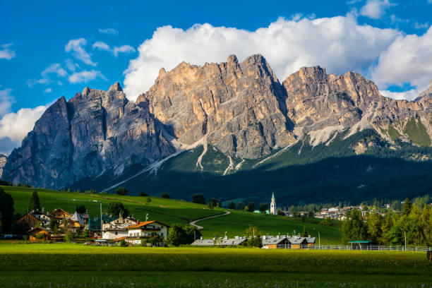 schöne aussicht auf cortina d'ampezzo stadt mit alpinen grünen landschaft und massiven dolomiten alpen im hintergrund. provinz belluno, südtirol, italien. künstlerisches bild. schönheitswelt - alp village meadow field stock-fotos und bilder