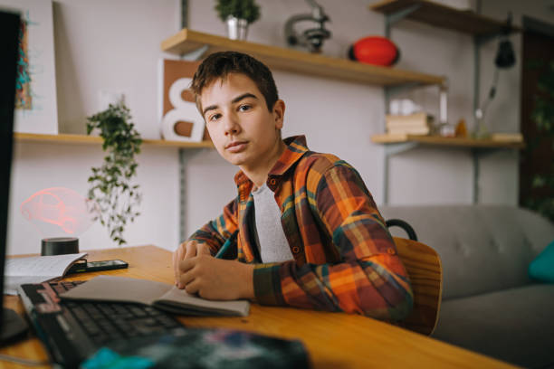 istock Teenage boy doing homework at home 1208465519