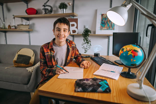 istock Teenage boy doing homework at home 1208465562