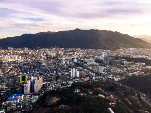 aerial sunset view of daegu basin and mountains landscape, with sanseongsan apsan mountains, duryu park road, daemyeong road, and residential areas in nam-gu south district in daegu city