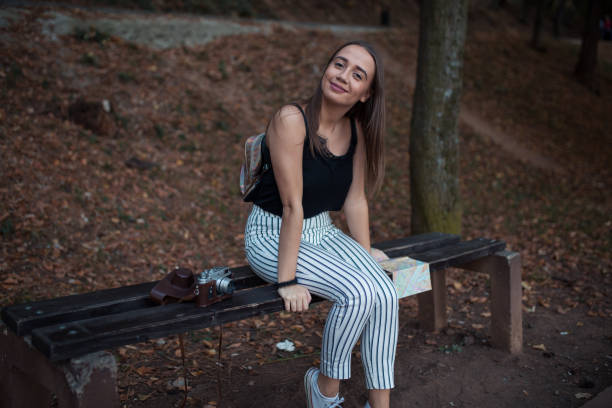 istock Young woman tourist sitting on bench 1208467681