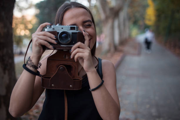 istock Young woman taking photos with analog camera on vacation 1208467783
