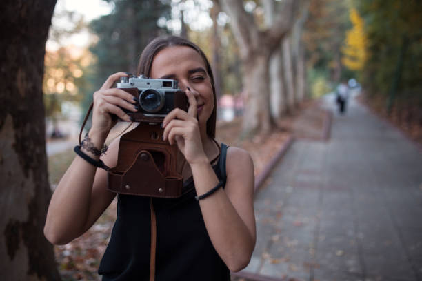 istock Young woman taking photos with camera 1208469042