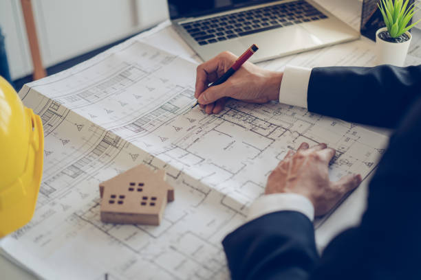 Architect & Engineer working drawing document about project planning and progress of work schedule on the home building construction site stock photo