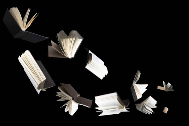 Flying several books isolated on black background. stock photo