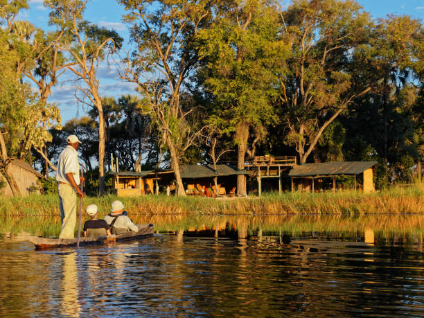 passageiros makoro no delta okavango chegando em um acampamento. botsuana, áfrica. - makoro - fotografias e filmes do acervo