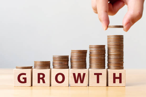 istock Hand putting coins on stack stair as step growing growth and wooden cube block with word GROWTH. Investment and save money increase concept 1208480277