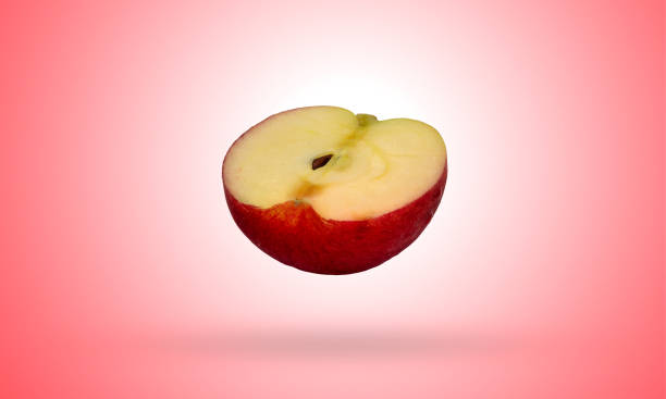 istock Red Apple cut in half isolated on gradients red and white background with clipping path 1208485160