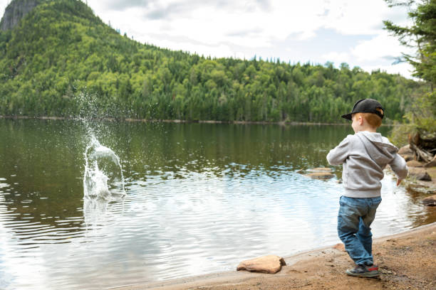 Little boy skimming stones in a lake