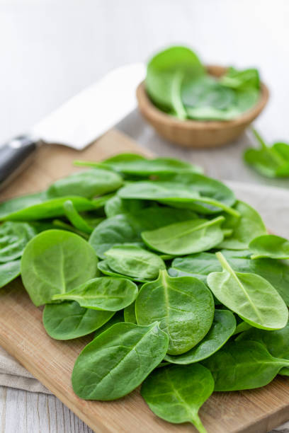 istock Green leaves spinach on a wooden cutting board 1208498645