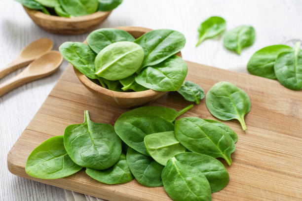 istock Green leaves spinach on a wooden cutting board 1208498663