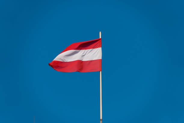 istock Austrian flag against blue sky, Austria 1208503423