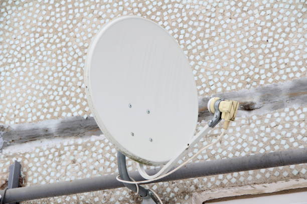istock Satellite dish fixed to the wall of a tiled house 1208507282