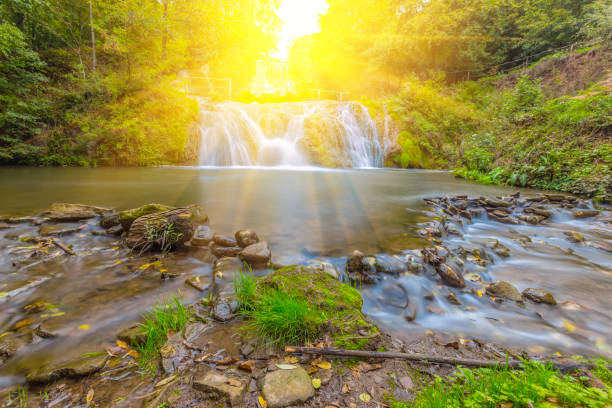 istock smalll waterfall in a rays of sun 1208509383
