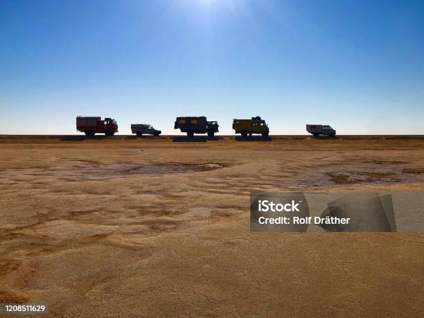 Side View Of 5 Cars Standing In A Line At A Flat With Blue Sky Above And Sunbeam Stock Photo - Download Image Now