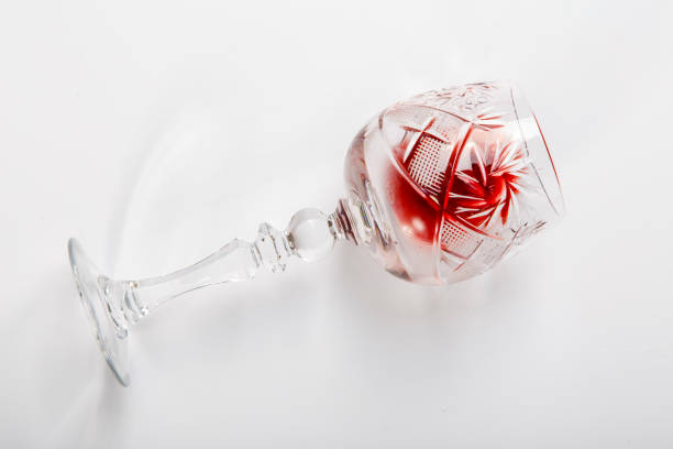 istock A glass of red wine lies on its side on a white background. 1208511792