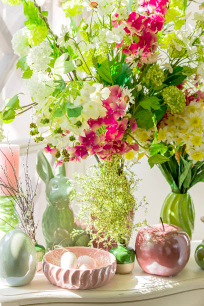 Easter interior decoration. Beatuful composition with candles. eggs, rabbit, apples and blooming flowers.