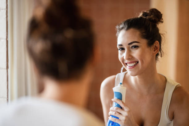 donna felice che pulisce i denti con filo interdentale in bagno. - healthy lifestyle human teeth adult brushing foto e immagini stock