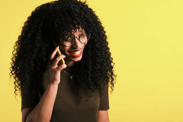 istock young curly haired afro american woman using her phone 1208515188