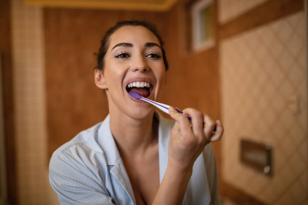 istock Beautiful woman brushing teeth in the bathroom. 1208515539