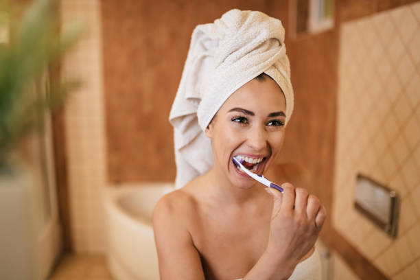 istock Young beautiful woman enjoying while toothbrushing in the bathroom. 1208516901
