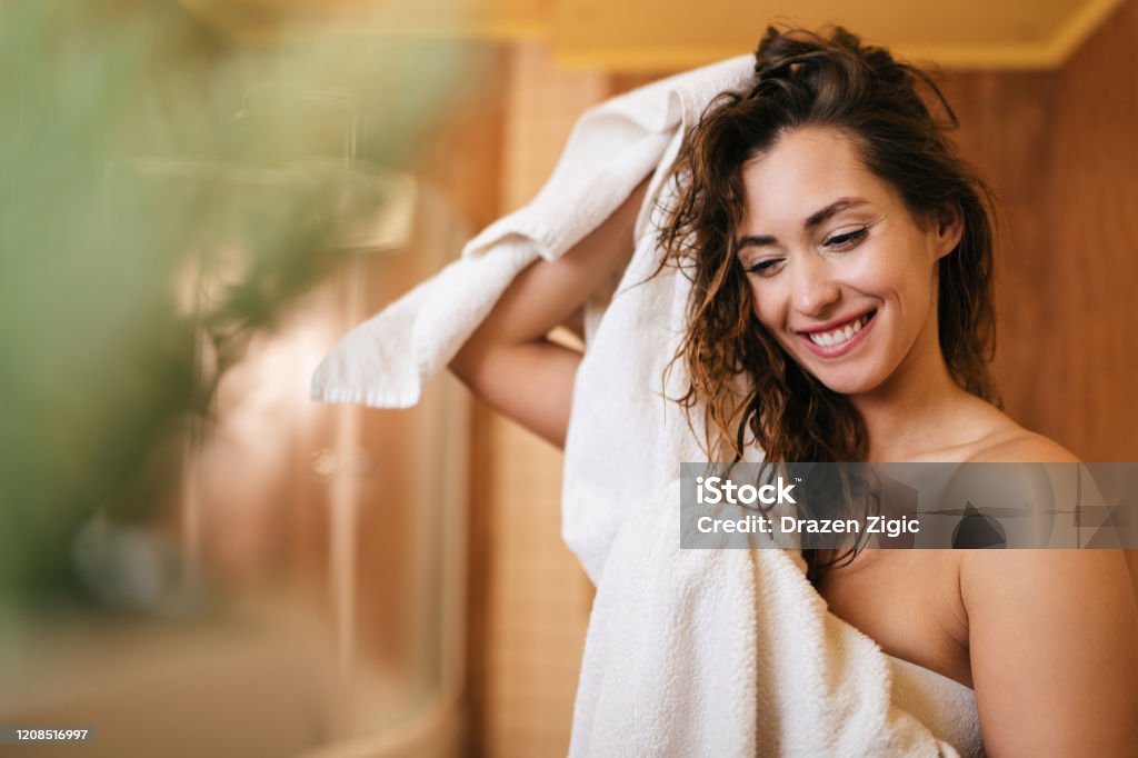 Linda mulher feliz secando o cabelo com uma toalha no banheiro. - Foto de stock de Mulheres royalty-free