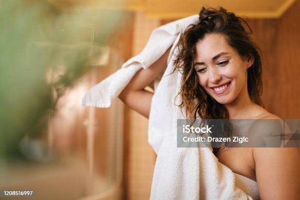 Foto de Linda Mulher Feliz Secando O Cabelo Com Uma Toalha No Banheiro e mais fotos de stock de Mulheres