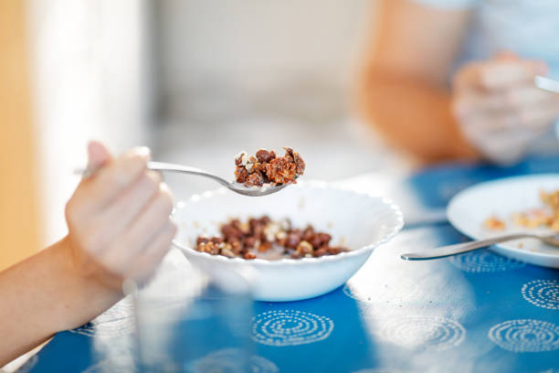 Holding a spoonfull of cereal with milk