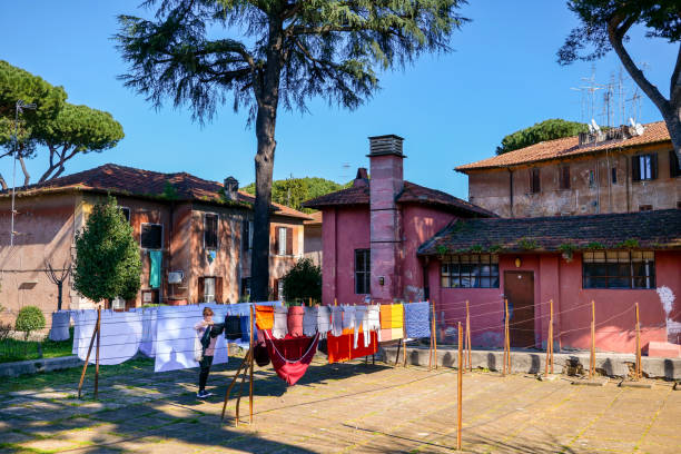 una mujer cuelga la ropa en el barrio de garbatella en el distrito ostiense de roma - villa italian culture facade ornamental garden fotografías e imágenes de stock