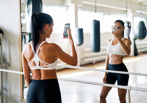 Young fit woman making a selfie in gym after exercise. Sport concept