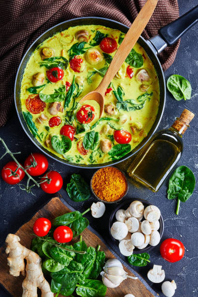 istock Lactose-free yellow coconut and mushroom curry with champignons, fresh spinach, cherry tomatoes 1208521368