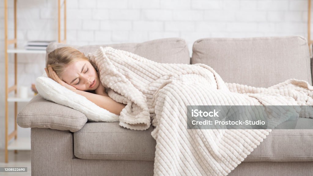 Betroffenes Mädchen liegt auf Couch in Decke gewickelt, Gefühl schlecht - Lizenzfrei Ansteckende Krankheit Stock-Foto