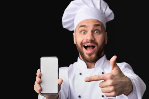 istock Excited Chef Guy Showing Cellphone Screen, Studio Shot, Mockup 1208522830