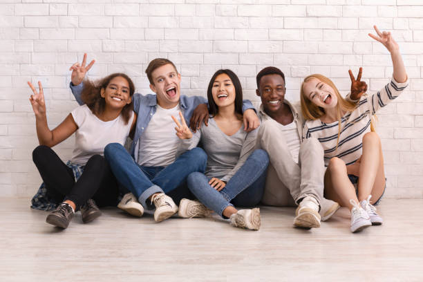 istock Emotional multiracial students sitting on floor and posing at camera 1208522889