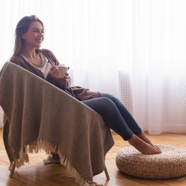 istock Cheerful woman resting with coffee at home 1208523036