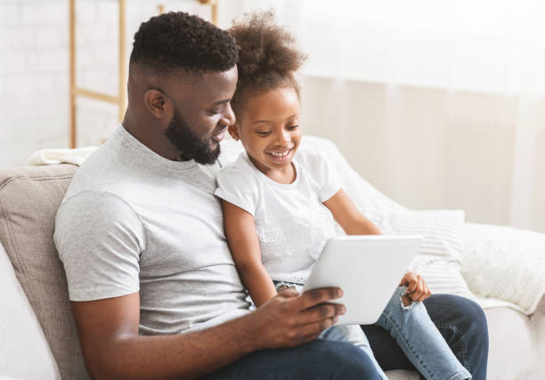 istock Afro dad and little daughter using digital tablet at home 1208523065