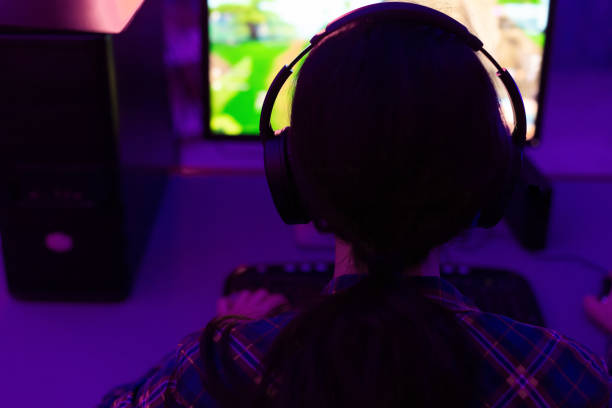 istock Female Gamer Playing Computer Game Sitting In Dark Room, Rear-View 1208523562