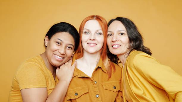 istock Group of positive multi-ethnic female friends completely different from each other posing against yellow background 1208523894