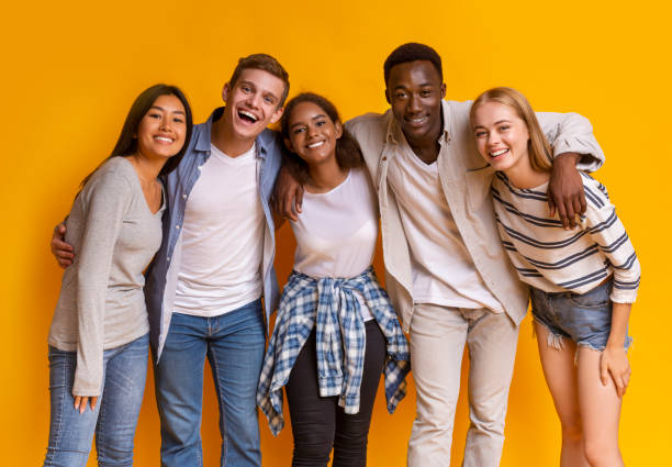 przyjazna grupa studentów z zagranicy uśmiechająca się na żółtym tle - fashion white black indoors zdjęcia i obrazy z banku zdjęć