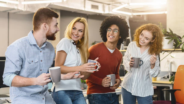 Smiling coworkers having tea during lunch break in coworking space Coworking concept. Smiling young coworkers having tea during lunch break in modern office, panorama office buddies stock pictures, royalty-free photos & images