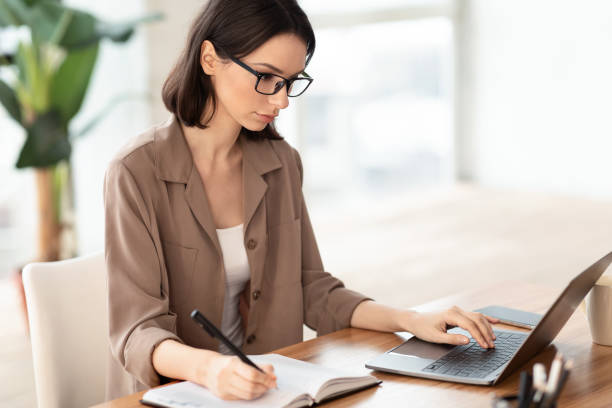 istock Portrait of manager using pc and writing 1208526369