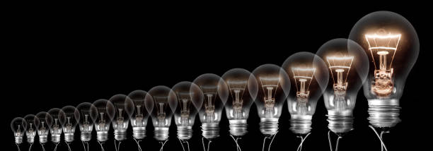istock Dark and Shining Light Bulbs Growing Row 1208527519