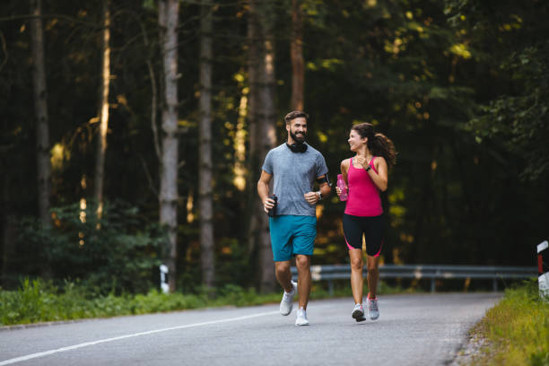 istock Young couple jogging in nature 1208529612