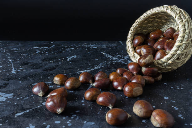 istock View of chestnuts falling from a wicker basket on a black background with gray polka dots 1208531903