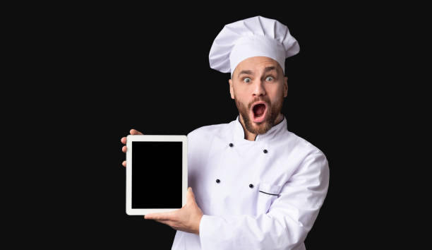 istock Shocked Chef Holding Digital Tablet Standing In Studio, Mockup 1208532255