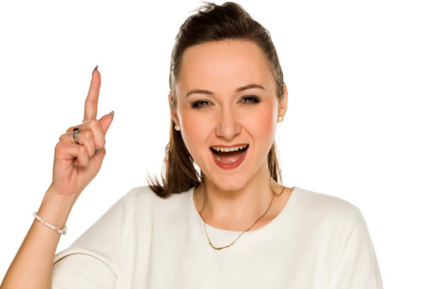 istock Happy woman with idea pointing up on white background 1208532421