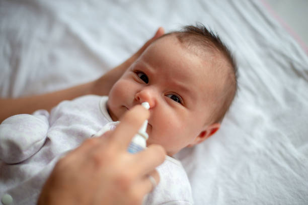 istock Woman using nasal spray for baby 1208532615