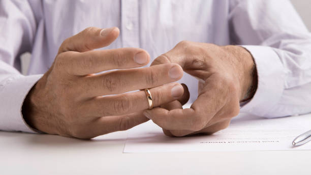 istock Man taking off wedding ring in lawyers office 1208532655