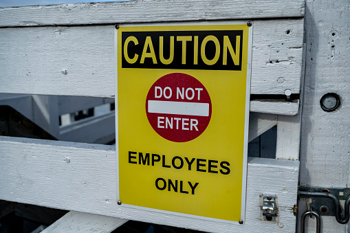 Old Silver fire door and sprinkler valve sign on a green wooden gate.